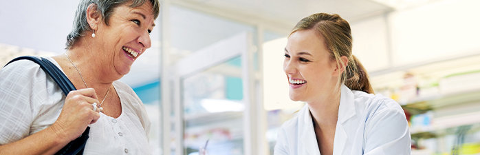 Pharmacist smiling while talking to a patient